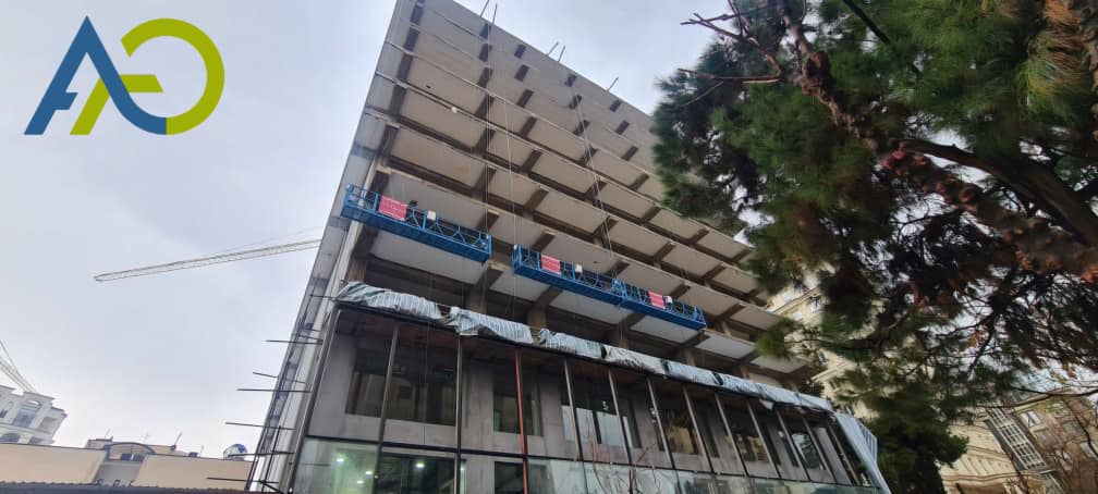 کلایمر برقی دو موتوره در حال کار روی نمای یک برج بلند برای سیمان کاری نما