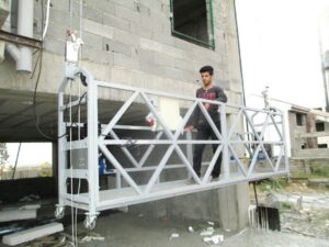 عامل داخل منصة معلقة آمنة مقابل عامل يعمل على سقالات خارجية تقليدية