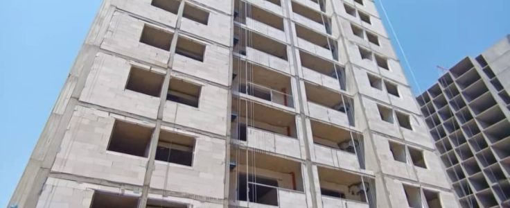 نمای یک برج مدرن با دستگاه کلایمر یا بالابر نما در حال کار برای بازسازی